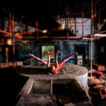 Graceful dancer leaps, industrial backdrop, mystical energy