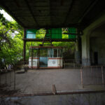 Dilapidated ropeway station overtaken by flourishing forest.